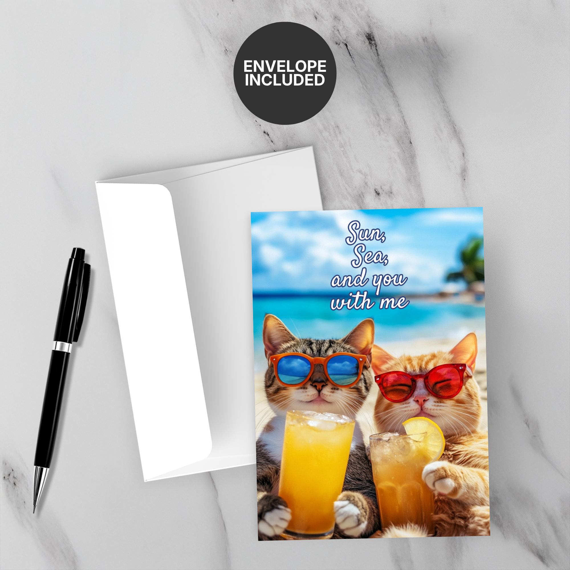 Greeting card with two cats enjoying drinks and sunglasses, accompanied by a pen and envelope on a marble surface.