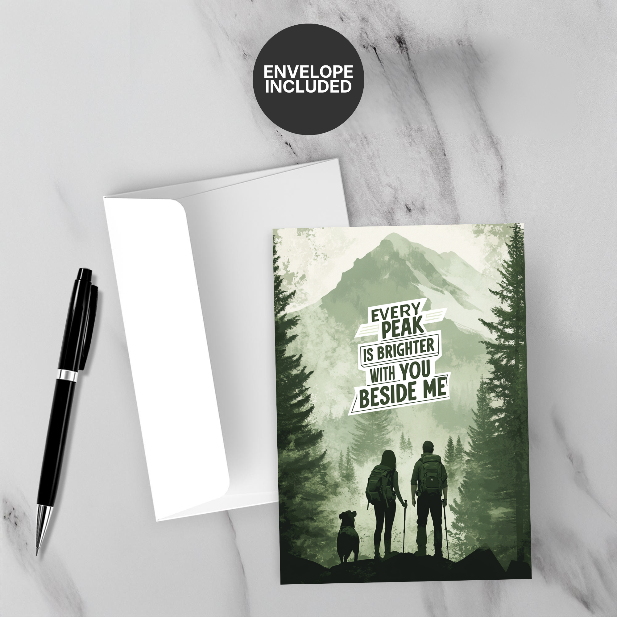 Greeting card with mountain and hiking silhouette, 'Every peak is brighter with you beside me' text, on a marble surface with a pen and envelope.