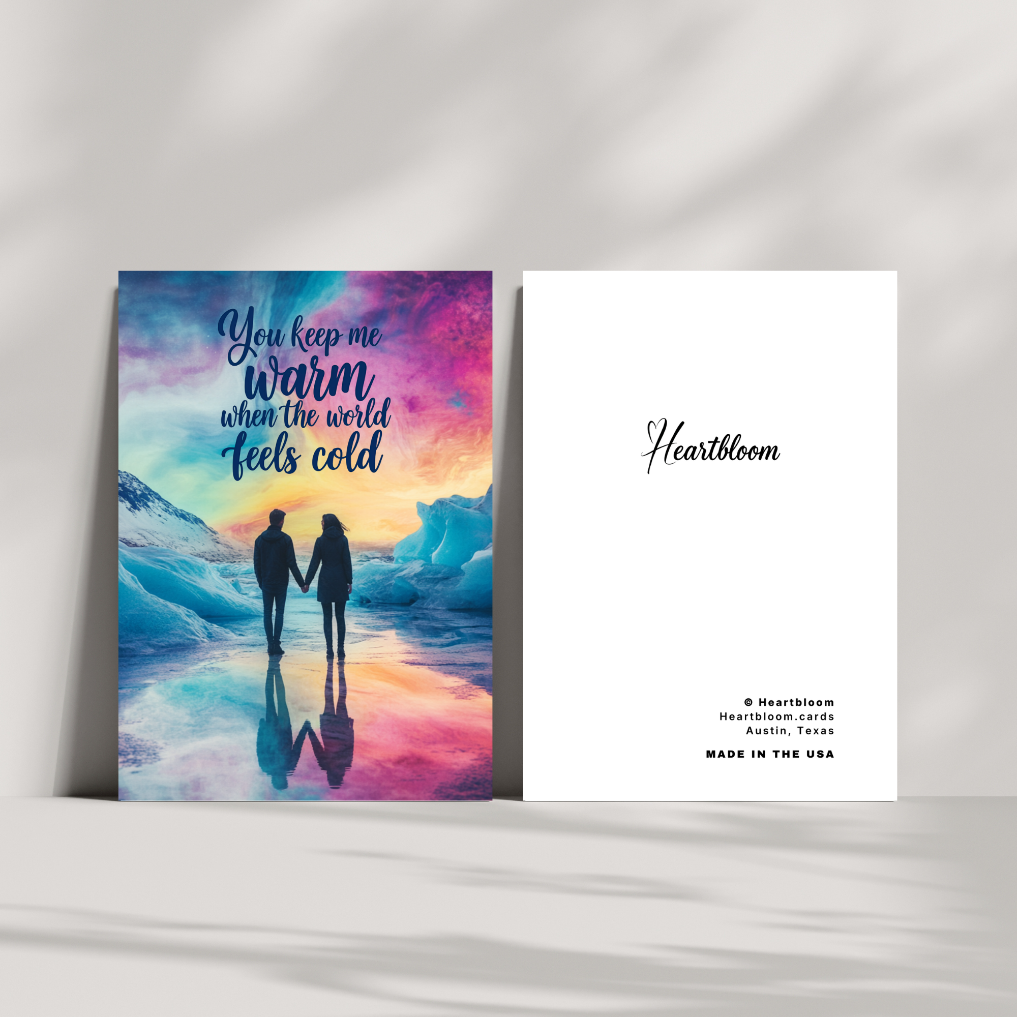 Heartbloom card with a couple holding hands on a colorful beach scene and the brand name 'Heartloom' on a white background.