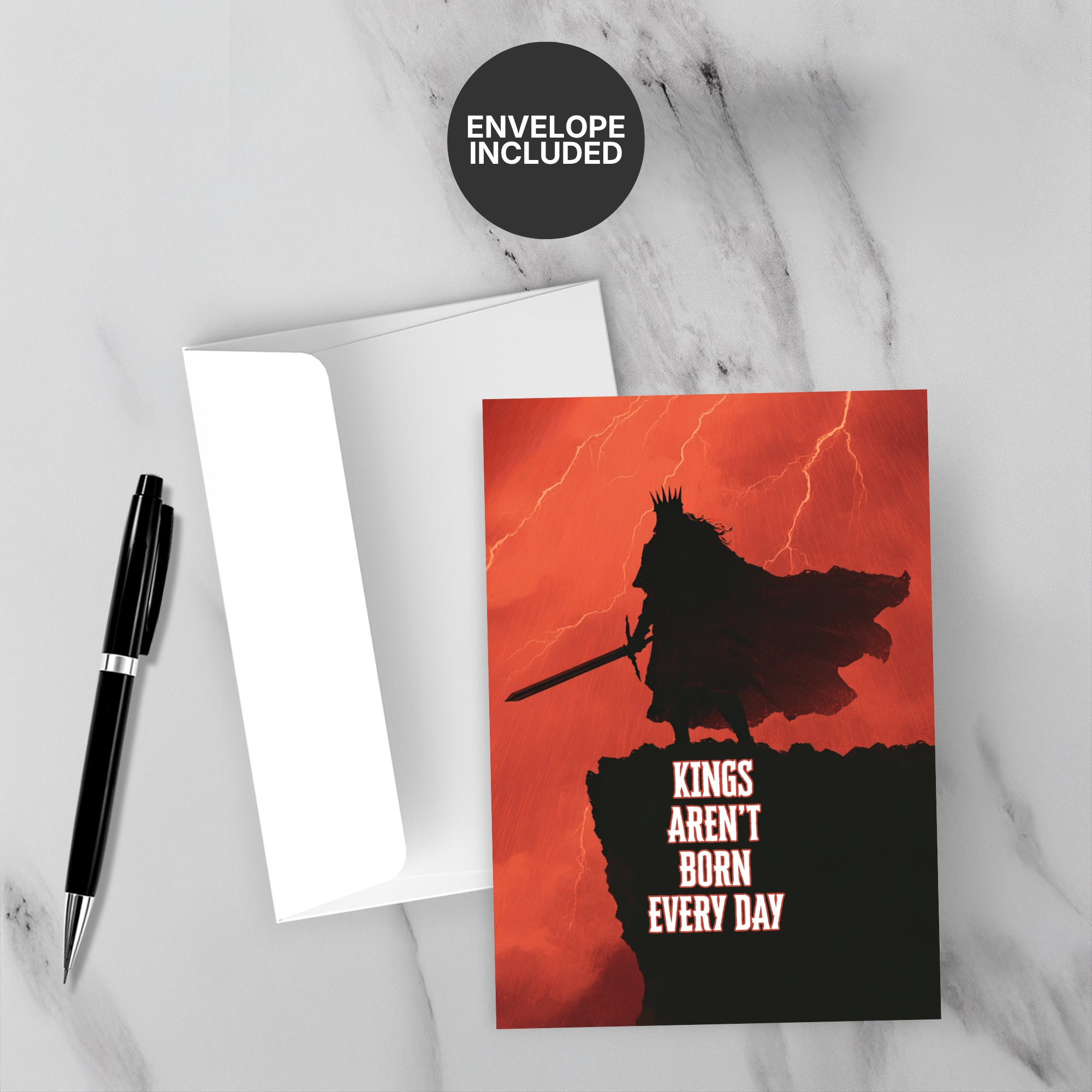 Greeting card with silhouette of a king and text 'Kings aren't born every day' on a red background, with a pen and white envelope.