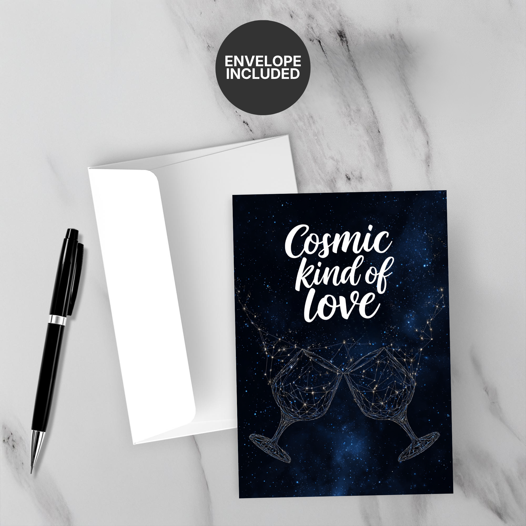 Greeting card with 'Cosmic Kind of Love' text and two wine glasses on a marble surface with a pen and envelope.
