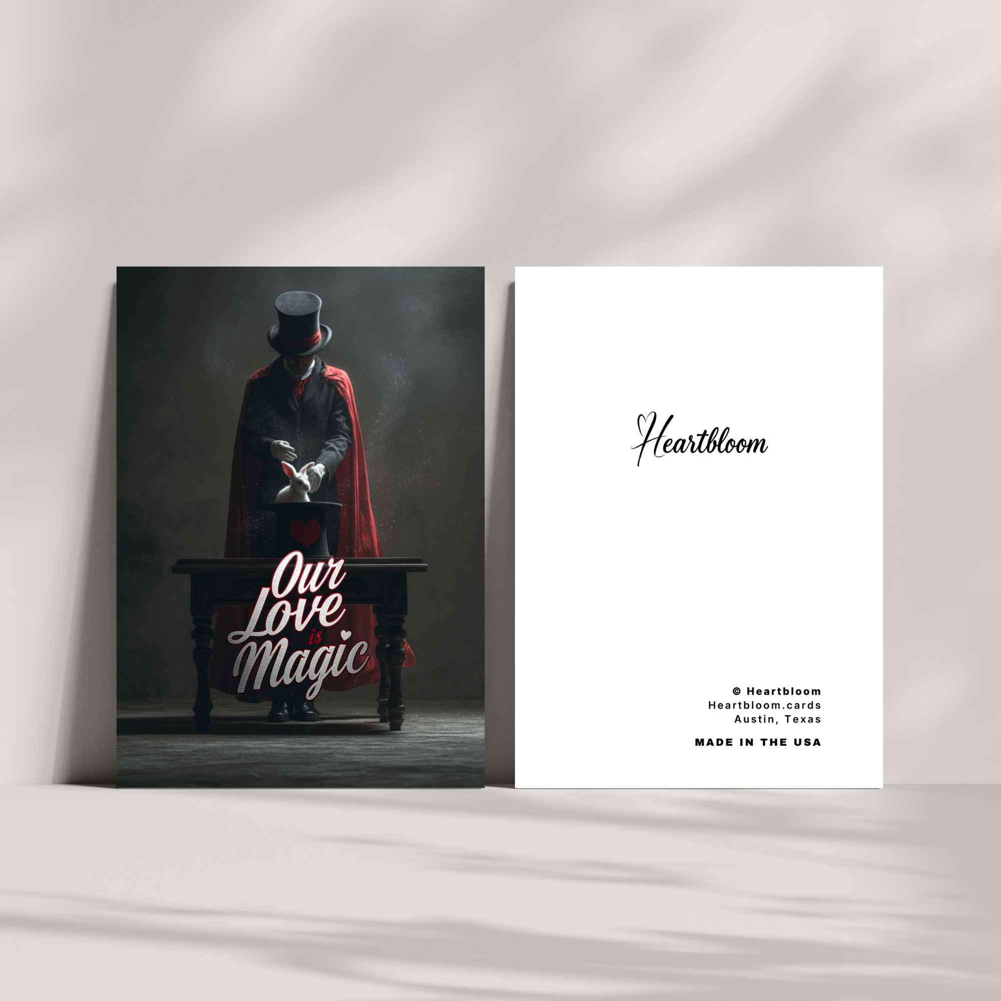 Card with a magician in a red cape and top hat, sitting at a desk with 'Our Love Magic' text, next to a 'Heartbloom' card on a white background.