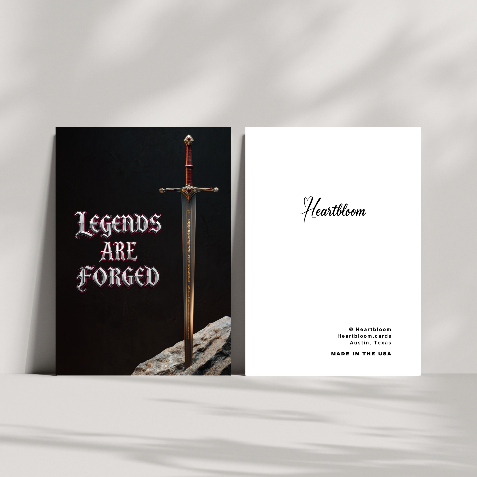 Card with a sword design and 'Legends Are Forged' text on a black background, alongside a white card with 'Heartbloom' branding.
