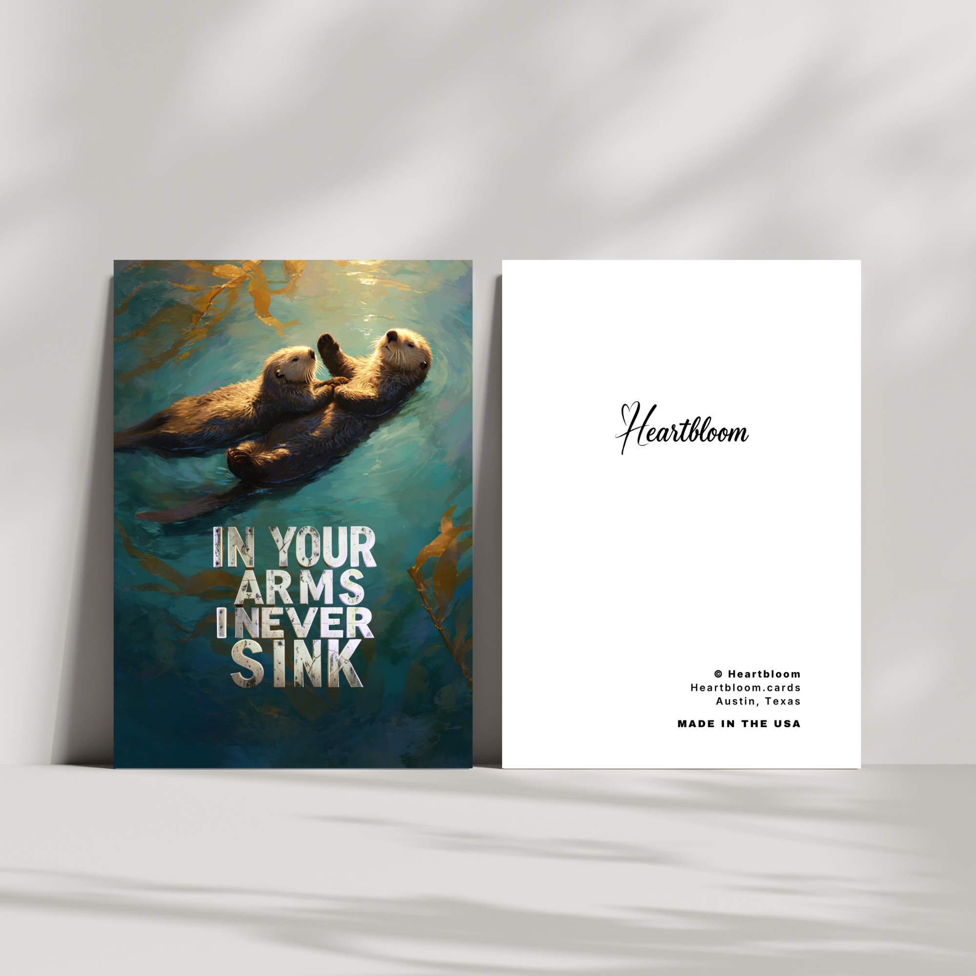 Card with two otters in water and 'Heartbloom' branding on a white background