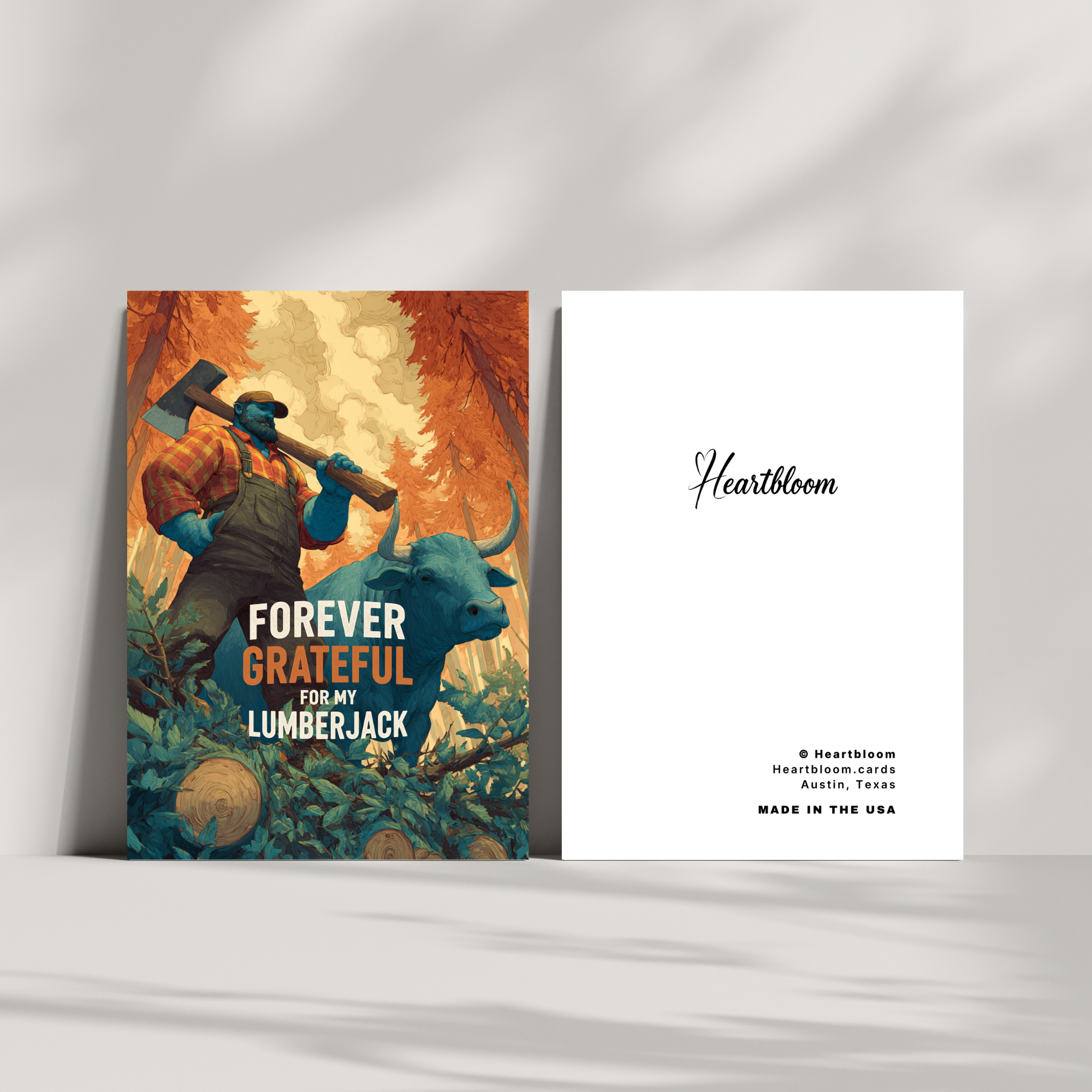 Two greeting cards on a white surface, one with a colorful illustration of a lumberjack and the other with text.