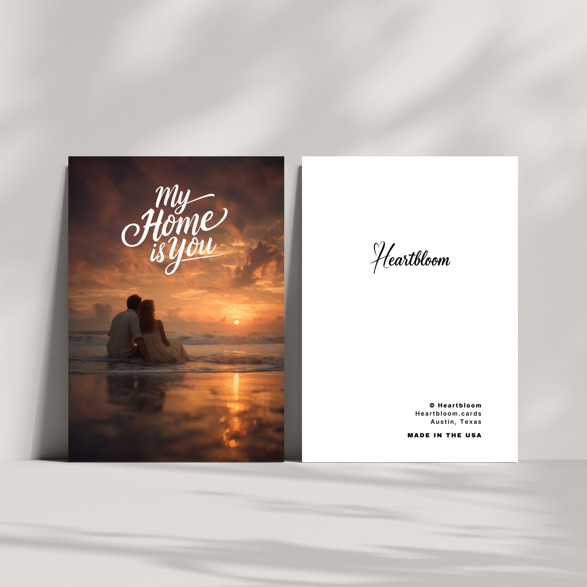 Heartloom card with a couple on a beach at sunset and brand name 'Heartloom' on a white card.