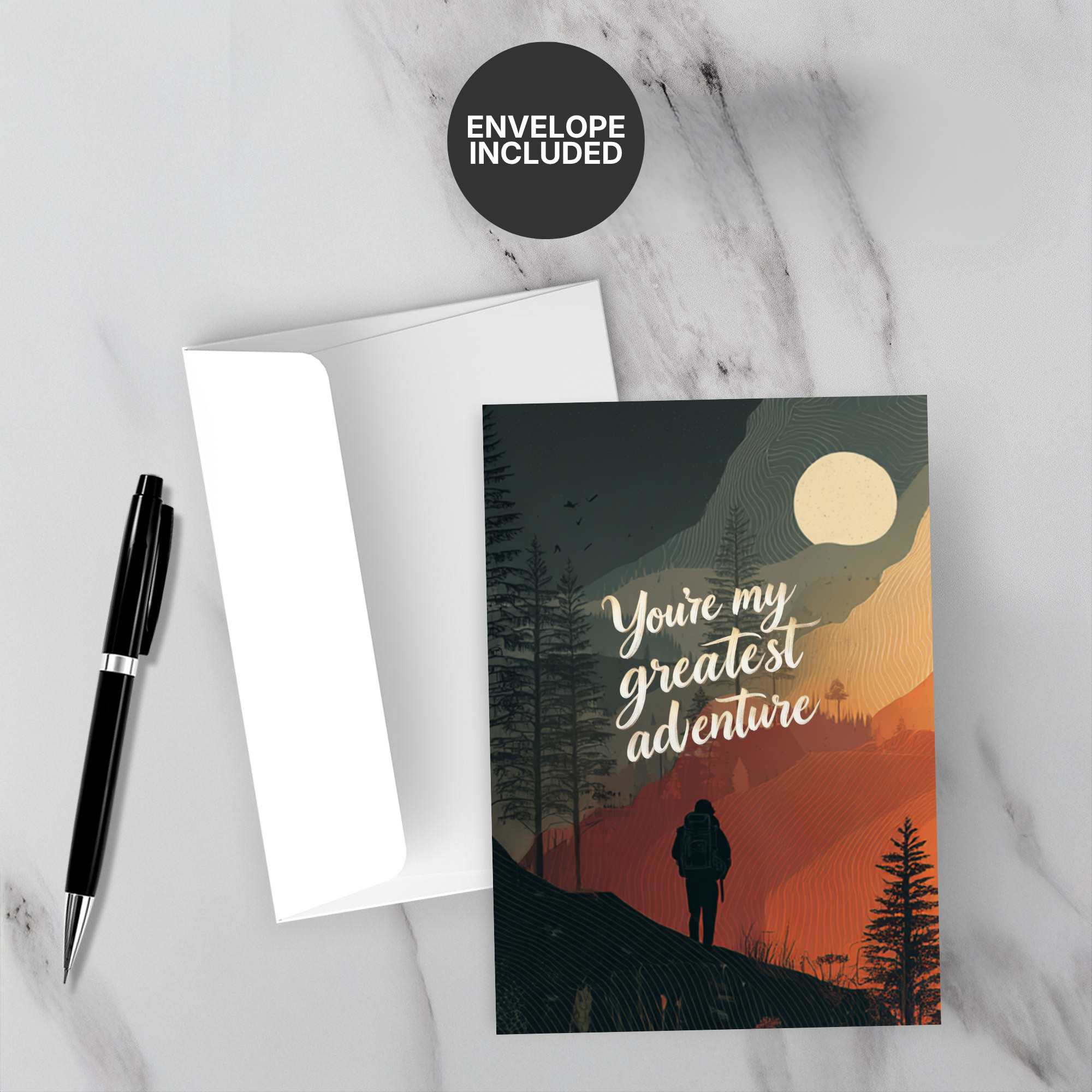 Greeting card with 'You're my greatest adventure' text, pen, and envelope on marble surface