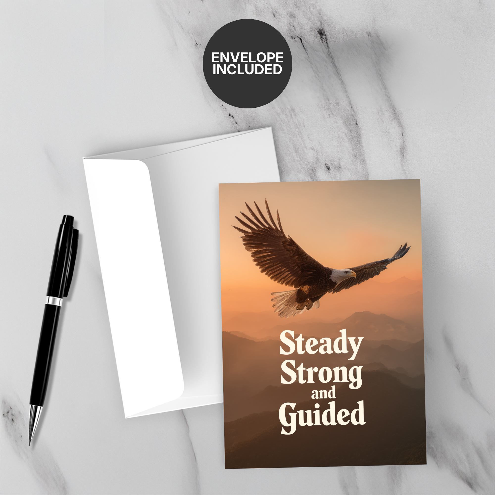 Greeting card with eagle design and motivational text on a marble surface with a pen and envelope.