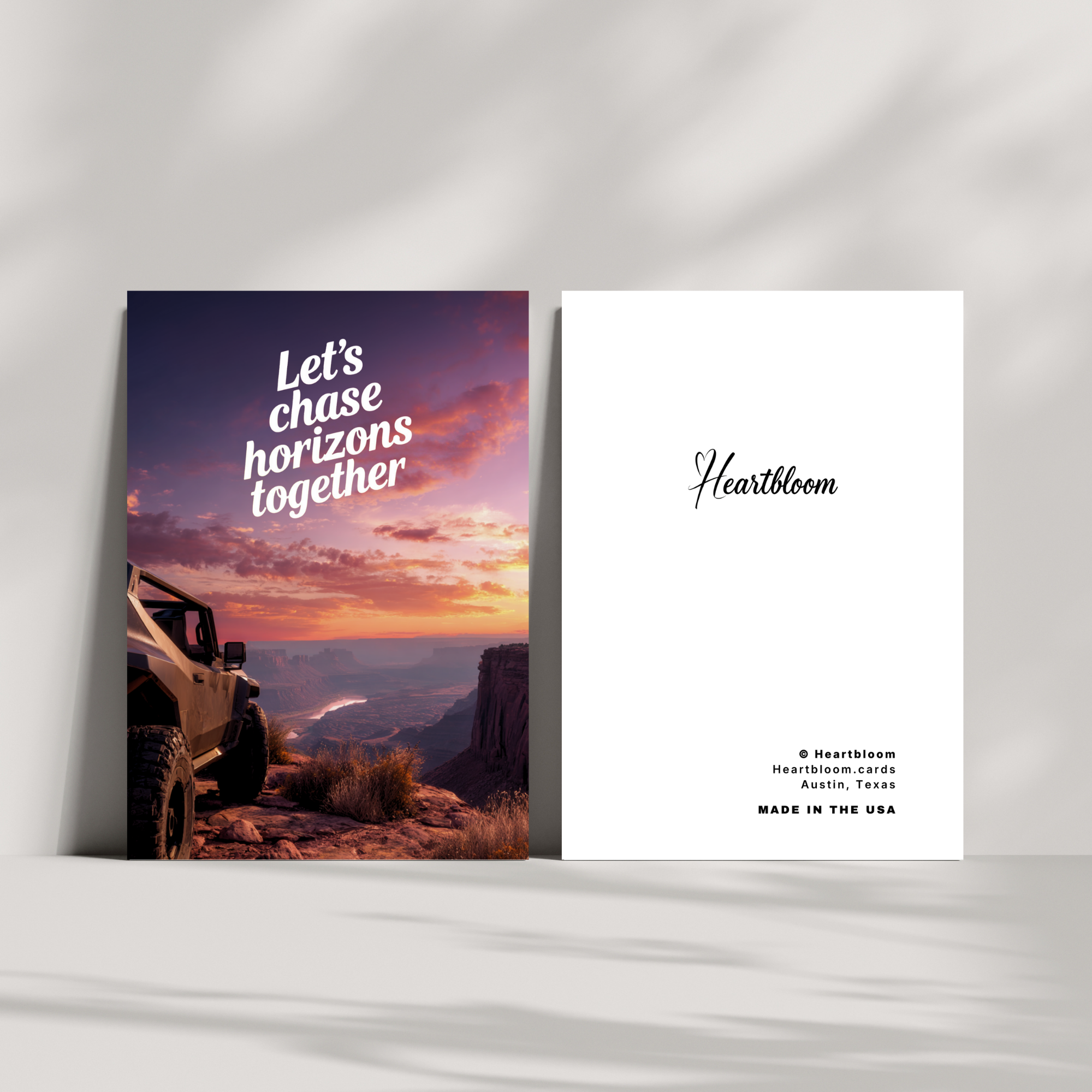 Card with off-road vehicle and sunset landscape on one side, and 'Heartbloom' branding on the other, against a white background.