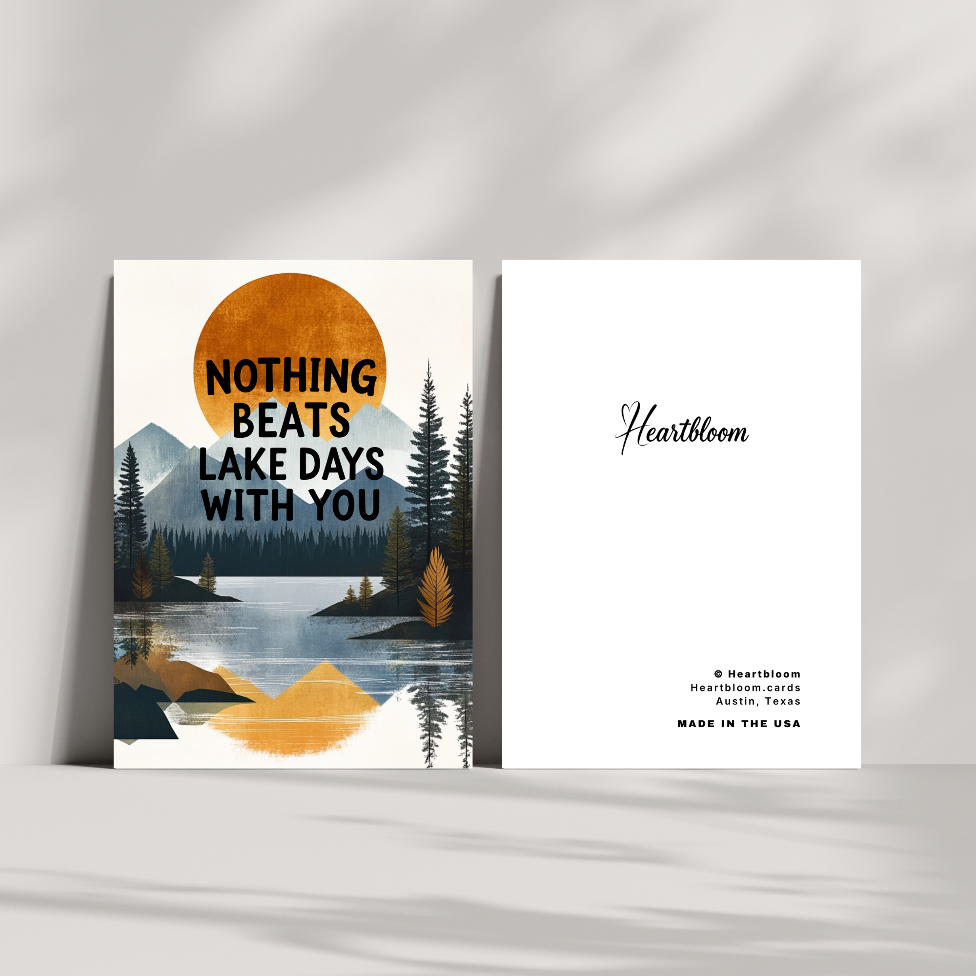 Card with a scenic design of a lake and mountains, featuring text 'Nothing beats lake days with you' and 'Heartbloom' branding.