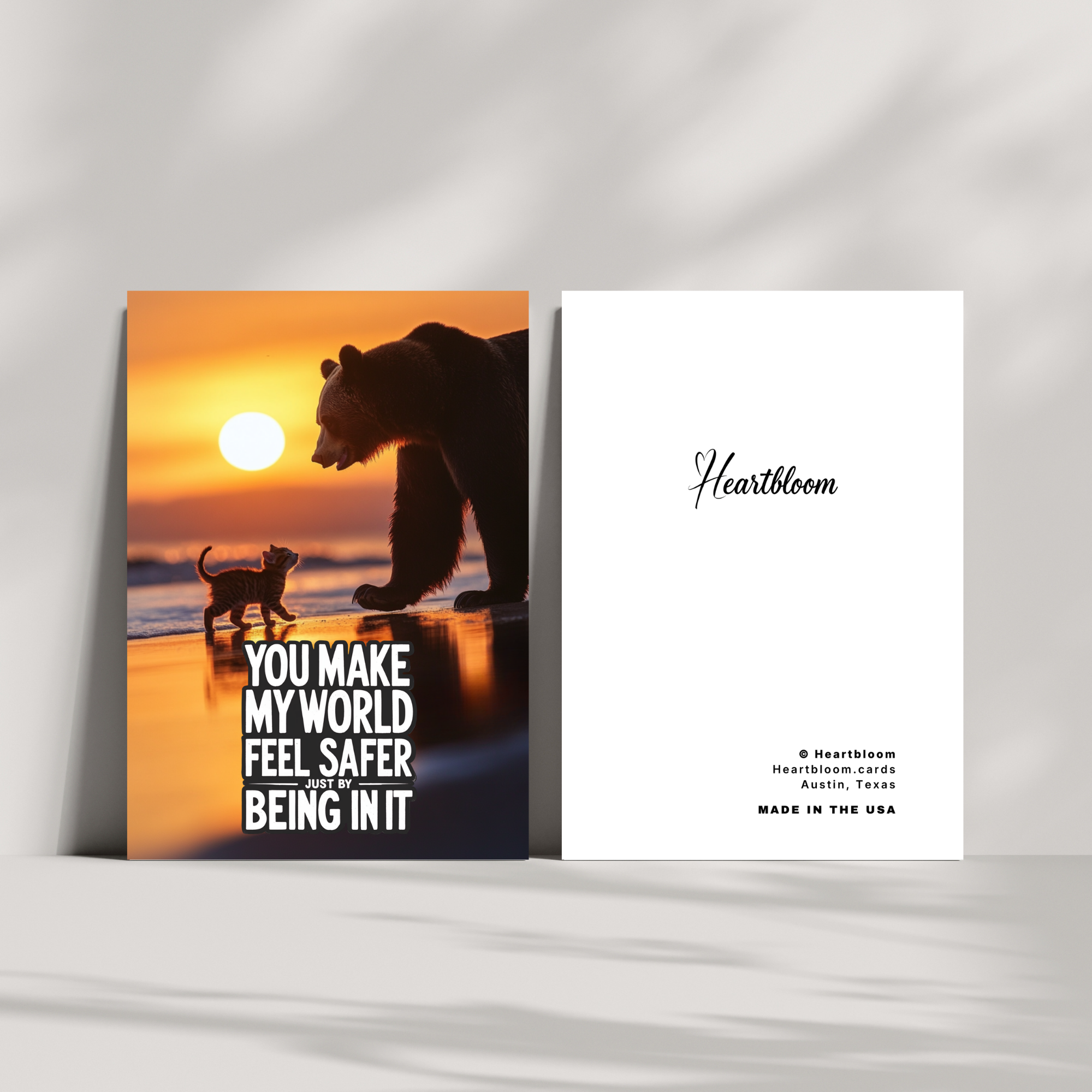 Card with bear and cat silhouette at sunset and 'Heartbloom' branding.