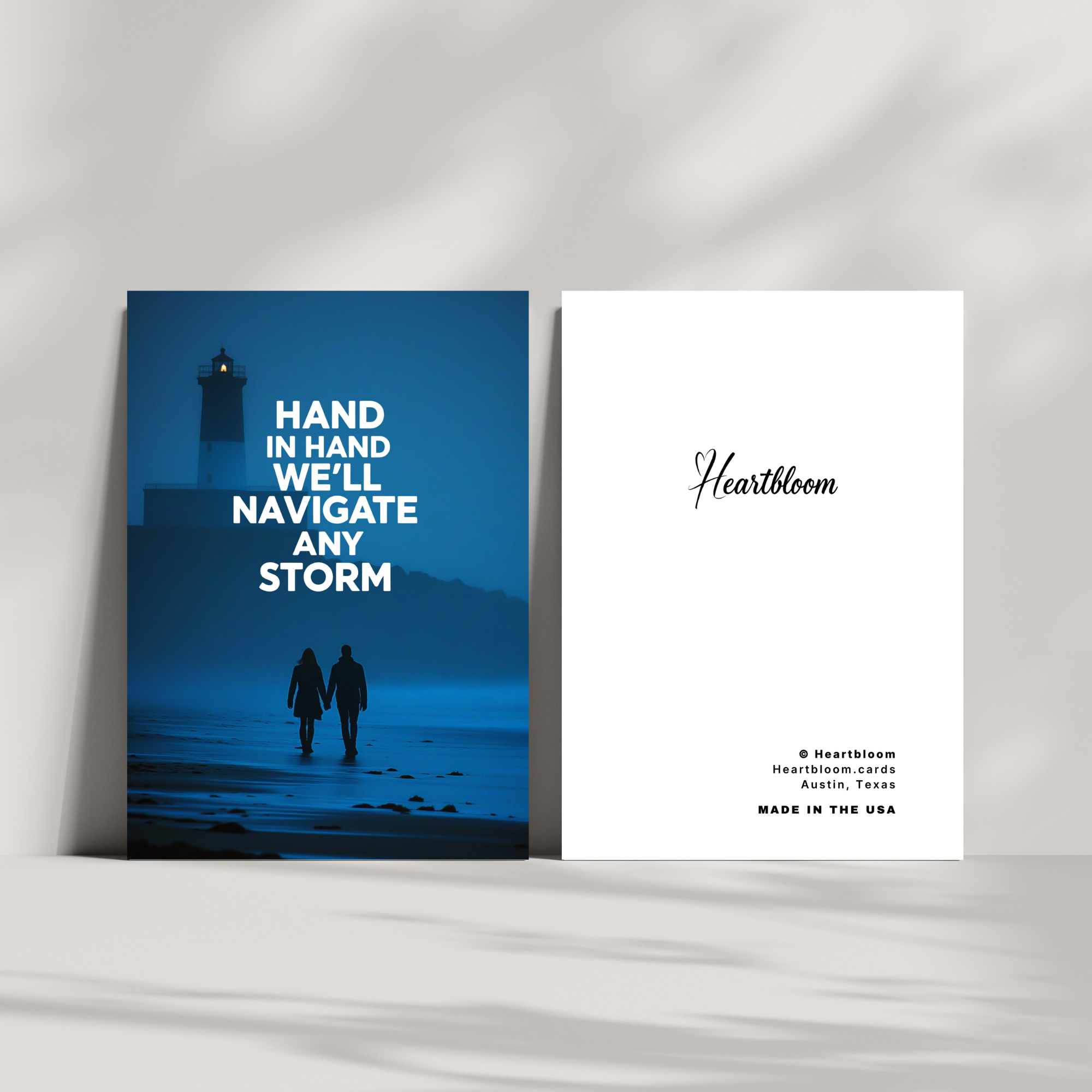 Two greeting cards on a white surface with a lighthouse and couple design.