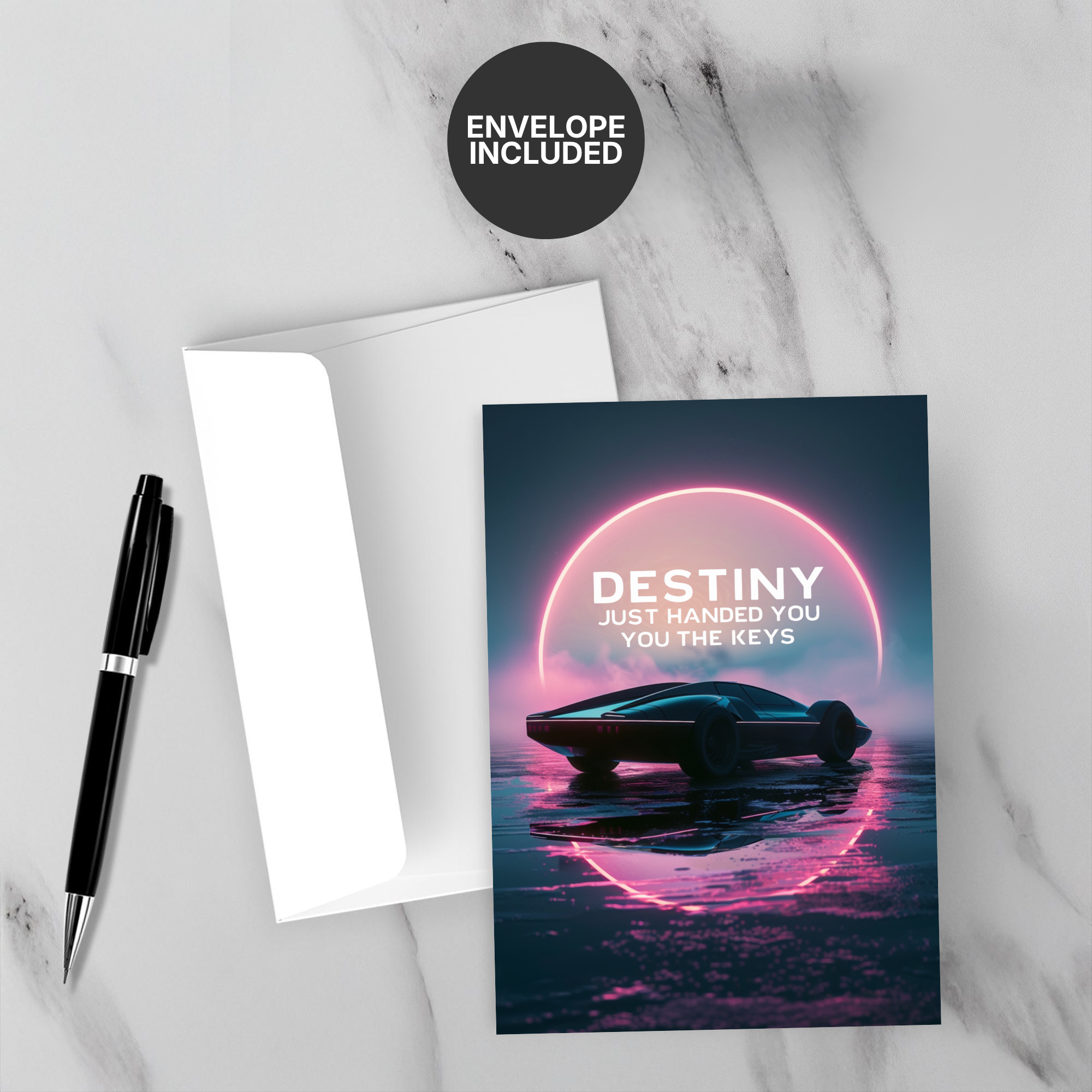 Greeting card with car and text 'Destiny just handed you the keys' on a marble surface with a pen and envelope.