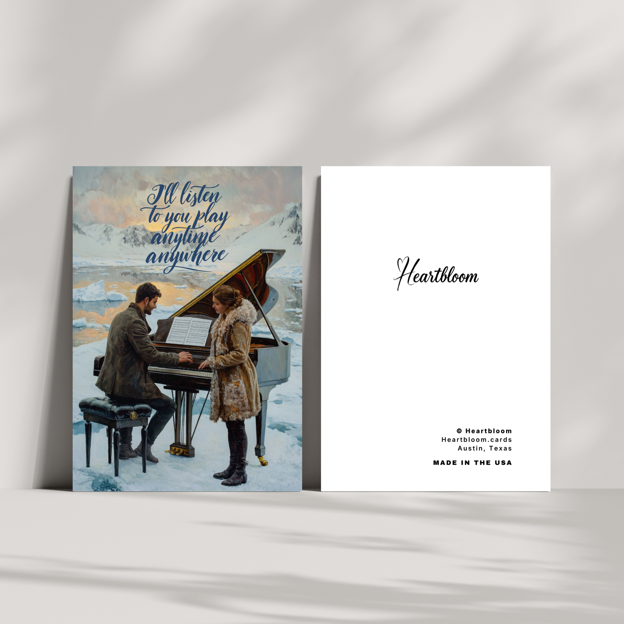 Greeting card with illustration of a couple by a piano in a snowy landscape, featuring the brand 'Heartbloom'.