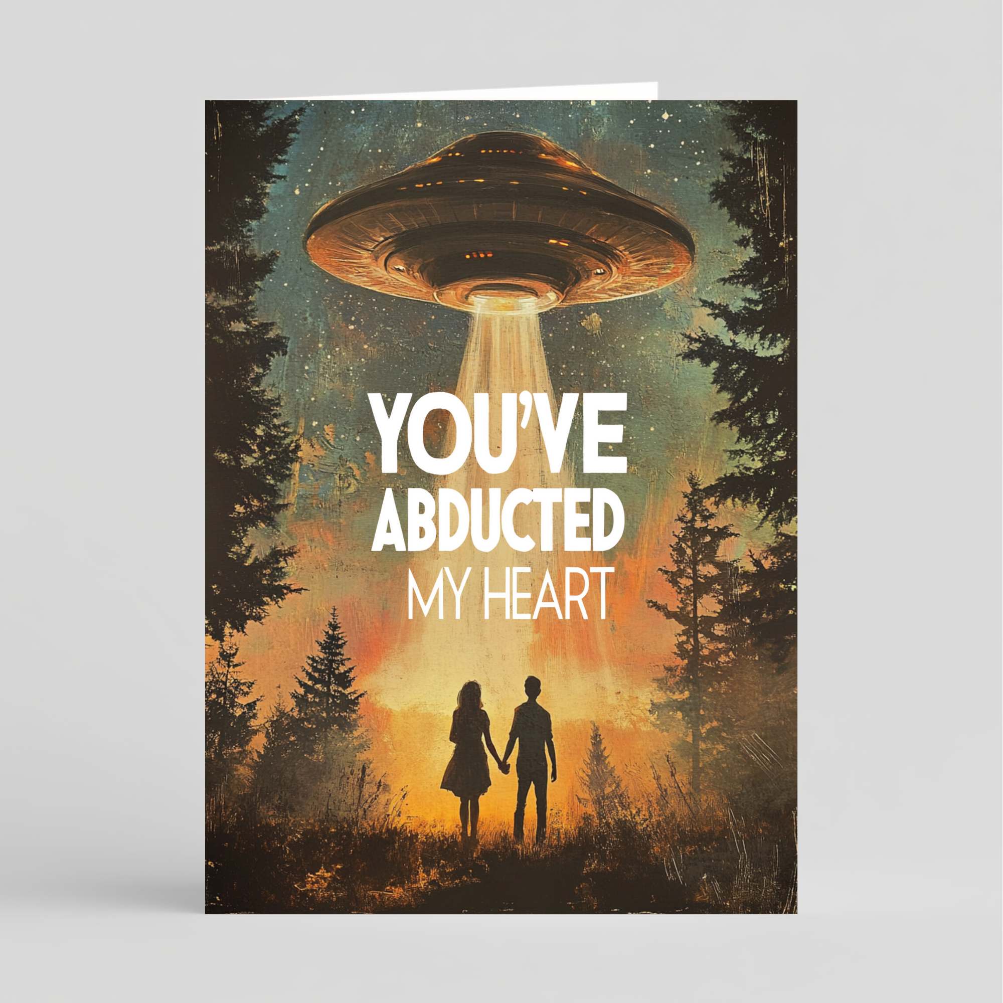 Card with UFO flying over a couple in a forest with 'You've Abducted My Heart' text
