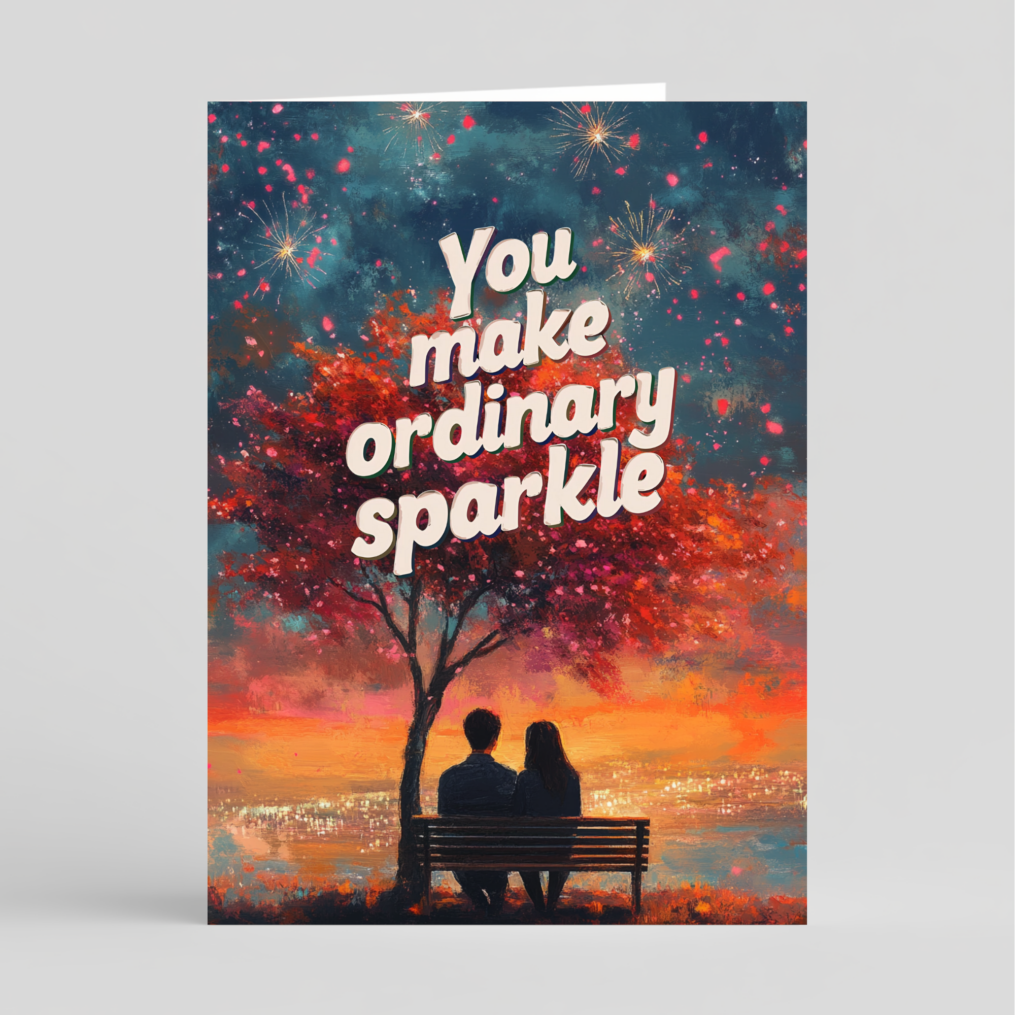 Greeting card with a romantic scene of a couple on a bench under a tree, with text 'You make ordinary sparkle' against a colorful sky.